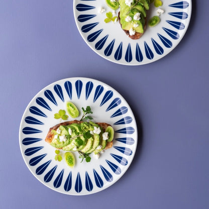 Two plates with avocado and feta cheese, beautifully presented on Lotus patterned servingware.